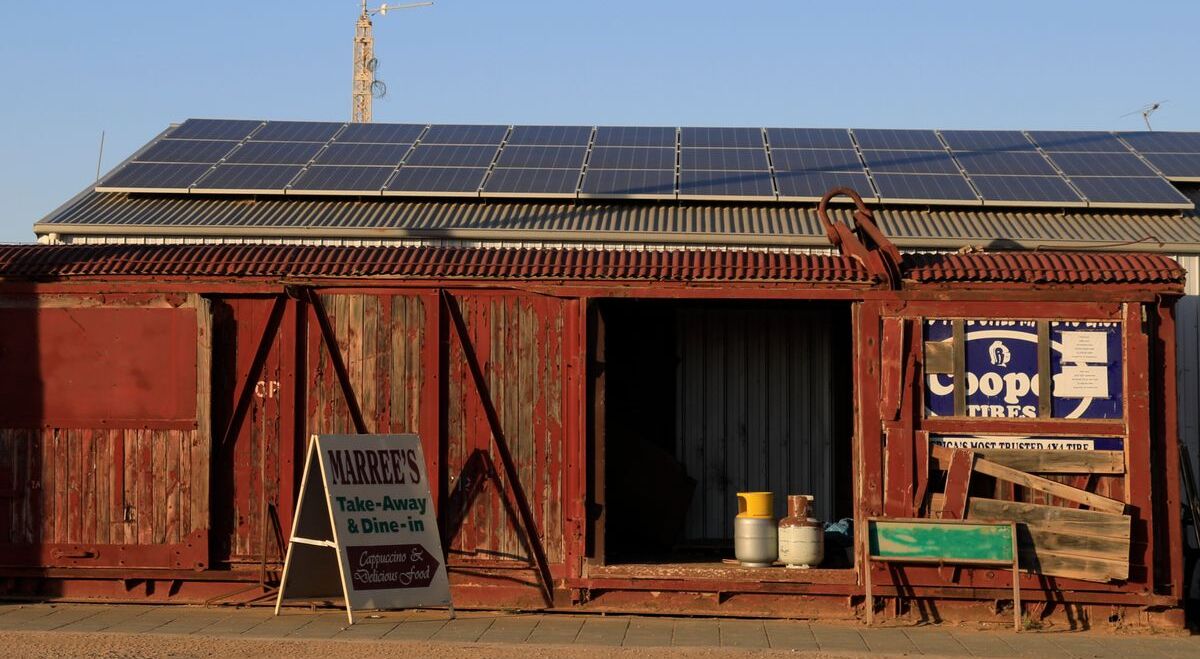Solar panels on an outback shed roof under a clear blue sky